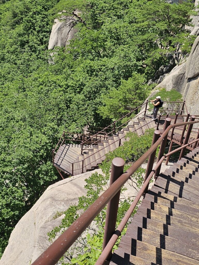 설악산 울산바위 정상 부근의 가파른  계단을 오르는 등산객의 모습