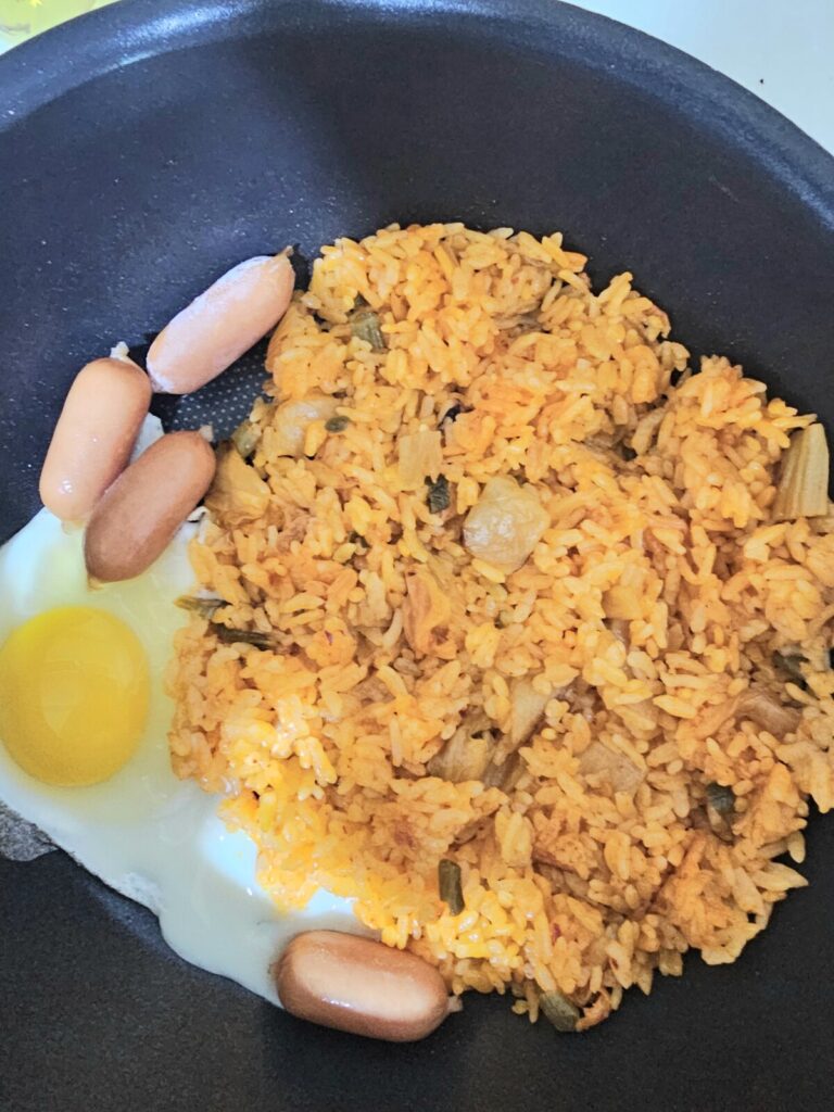 프라이팬에 한우물김치볶음밥 과 계란, 비엔나소세지를 함께 넣고 조리하는 모습